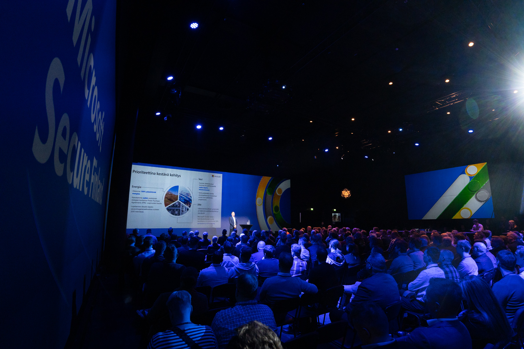 Event venue filled with people listening to a presentation