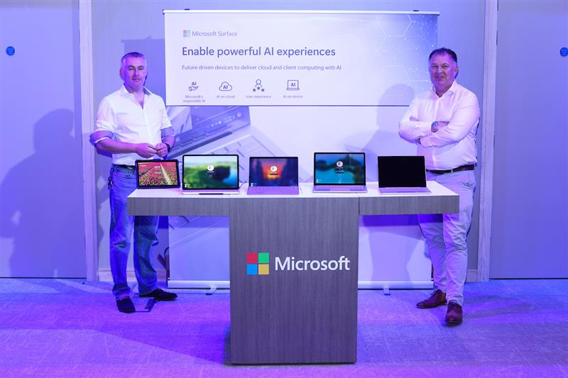 two men in front of ms console at event